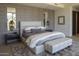 Stylish bedroom with a padded headboard, textured wallpaper, and a gray padded bench at 4451 E Joshua Tree Ln, Paradise Valley, AZ 85253