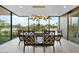 Elegant dining area with modern light fixture and views of the manicured backyard landscaping at 4451 E Joshua Tree Ln, Paradise Valley, AZ 85253