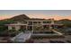 Aerial dusk shot of a modern home with a luxurious pool, mountain views, and stunning outdoor landscape at 4451 E Joshua Tree Ln, Paradise Valley, AZ 85253