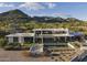 Stunning contemporary home with a pool, set against a backdrop of scenic mountains and desert landscape at 4451 E Joshua Tree Ln, Paradise Valley, AZ 85253