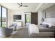 This light-filled main bedroom has a sliding barn door, accent wall, and comfortable seating at 4451 E Joshua Tree Ln, Paradise Valley, AZ 85253