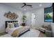 Bright bedroom with queen bed, ceiling fan, accent wall and large window with seating at 4451 E Joshua Tree Ln, Paradise Valley, AZ 85253