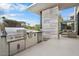 Outdoor kitchen with stainless steel grill, under-counter refrigerator, and bar seating near the backyard living area at 4451 E Joshua Tree Ln, Paradise Valley, AZ 85253