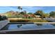 Beautiful in-ground pool with mountain views and lush landscaping reflecting in the water's surface at 4451 E Joshua Tree Ln, Paradise Valley, AZ 85253