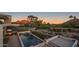 Aerial view of an in-ground pool with an outdoor fireplace and mountain views at sunset at 4451 E Joshua Tree Ln, Paradise Valley, AZ 85253