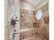 Luxurious bathroom shower with custom travertine tile, bench and window at 4636 E Monte Way, Phoenix, AZ 85044