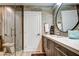 Bathroom featuring wood-look tile, glass shower, modern vanity, and contemporary round mirror at 5674 N 12Th St, Phoenix, AZ 85014