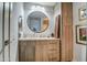 Bathroom features a granite counter, dark wood cabinets, and a round mirror at 5674 N 12Th St, Phoenix, AZ 85014