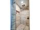 Shower featuring wood-look tile, pebble flooring, rainfall shower head, and built-in shelving at 5674 N 12Th St, Phoenix, AZ 85014