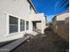 Backyard with covered patio, gravel landscaping and adjacent privacy wall at 6455 W Orchid Ln, Glendale, AZ 85302
