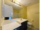 Well-lit bathroom with dark vanity, large mirror, and shower/tub at 6455 W Orchid Ln, Glendale, AZ 85302