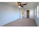 Bedroom featuring carpet, a ceiling fan, a closet, and large windows at 6455 W Orchid Ln, Glendale, AZ 85302