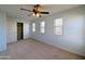 Bright bedroom featuring neutral carpet, ceiling fan, closet and three windows at 6455 W Orchid Ln, Glendale, AZ 85302
