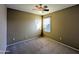 Bedroom with a large window, neutral carpet, and ceiling fan at 6455 W Orchid Ln, Glendale, AZ 85302
