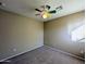 Standard bedroom featuring tan walls, neutral carpet, and ceiling fan at 6455 W Orchid Ln, Glendale, AZ 85302
