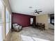 This open dining area features neutral tile, a burgundy accent wall, and an adjacent living area at 6455 W Orchid Ln, Glendale, AZ 85302