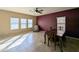 Open dining area features neutral tile, a burgundy accent wall, and chair-rail accents at 6455 W Orchid Ln, Glendale, AZ 85302