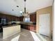 Bright kitchen with island, tile floor, stainless appliances, and dark cabinets. Backyard access at 6455 W Orchid Ln, Glendale, AZ 85302