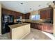 Bright kitchen featuring granite countertops, an island, stainless steel appliances, and dark cabinets at 6455 W Orchid Ln, Glendale, AZ 85302
