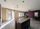 Bright kitchen with island, tile floor, backyard access, and view of the dining and sitting area at 6455 W Orchid Ln, Glendale, AZ 85302