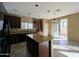 Well-equipped kitchen with granite countertops, dark wood cabinets, kitchen island, and backyard access at 6455 W Orchid Ln, Glendale, AZ 85302