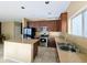Bright kitchen featuring granite countertops, an island, stainless steel appliances, and dark cabinets at 6455 W Orchid Ln, Glendale, AZ 85302