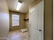 Functional laundry room with tile flooring, natural light, and a utility sink at 6455 W Orchid Ln, Glendale, AZ 85302