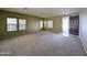 Spacious living room with carpet, natural light from windows, and a view of the front entry at 6455 W Orchid Ln, Glendale, AZ 85302