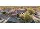 An aerial view of a desert home featuring a spacious driveway, tile roof, and desert landscaping at 7735 E Russell Cir, Mesa, AZ 85207