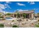 Expansive backyard with a pool, covered patio, desert landscaping, and outdoor grill area at 7735 E Russell Cir, Mesa, AZ 85207