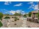 Lush backyard with a pool, desert landscaping, rock features, and a built-in outdoor grill at 7735 E Russell Cir, Mesa, AZ 85207