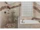 Serene bathroom with tiled shower, relaxing tub, and block glass window for added light at 7735 E Russell Cir, Mesa, AZ 85207