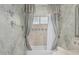 Bathroom showing a tub with decorative tile, gray drapes, and decorative mirror at 7735 E Russell Cir, Mesa, AZ 85207