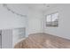 Bright bedroom with wood-look floors, a large window, and a convenient built-in bookshelf at 7735 E Russell Cir, Mesa, AZ 85207