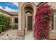 Inviting front entrance framed by vibrant bougainvillea and decorative glass at 7735 E Russell Cir, Mesa, AZ 85207