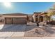 Charming home featuring a two-car garage, desert landscaping, and a tile roof at 7735 E Russell Cir, Mesa, AZ 85207