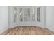 Bright room featuring wood floors, white walls, and windows with shutters for natural light and privacy at 7735 E Russell Cir, Mesa, AZ 85207