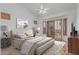 Bedroom features a ceiling fan, neutral walls, wood-look floors, and bay window with light-blocking shutters at 7735 E Russell Cir, Mesa, AZ 85207