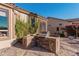 Outdoor kitchen featuring a built-in grill and countertop space surrounded by desert landscaping and mature plants at 7735 E Russell Cir, Mesa, AZ 85207