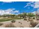 Scenic park view with a walking path and desert landscaping under a clear blue sky with scattered clouds at 7735 E Russell Cir, Mesa, AZ 85207