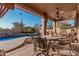 Covered patio featuring comfortable seating, a ceiling fan, and view of the pool and desert landscaping at 7735 E Russell Cir, Mesa, AZ 85207