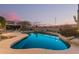Inviting pool with desert landscaping, rock features, and picturesque sunset views, ideal for relaxation and entertainment at 7735 E Russell Cir, Mesa, AZ 85207