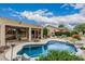 Inviting pool area with lush landscaping, covered patio, and serene backyard setting at 7735 E Russell Cir, Mesa, AZ 85207