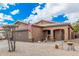 Tan house with brown garage door, landscaping, and American flag at 830 E Tortoise Trl, San Tan Valley, AZ 85143