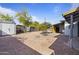 Spacious backyard featuring rock ground cover, shed, mature trees, and seating area at 9410 N 4Th Ave, Phoenix, AZ 85021