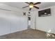 Cozy bedroom featuring carpeted floors, ceiling fan, closet space, and a wall-mounted television at 9410 N 4Th Ave, Phoenix, AZ 85021