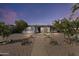 Charming home with desert landscaping, rock lined yard and mature trees under a colorful evening sky at 9410 N 4Th Ave, Phoenix, AZ 85021