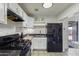 Bright kitchen with white cabinets, black appliances, and tiled backsplash; perfect for cooking at 9410 N 4Th Ave, Phoenix, AZ 85021
