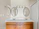 Bathroom featuring a double sink vanity, framed mirrors, and a walk-in shower at 955 E Vaughn Ave, Gilbert, AZ 85234