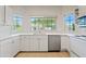 Bright kitchen features white cabinetry, stainless steel appliances, and a garden window above the sink at 955 E Vaughn Ave, Gilbert, AZ 85234